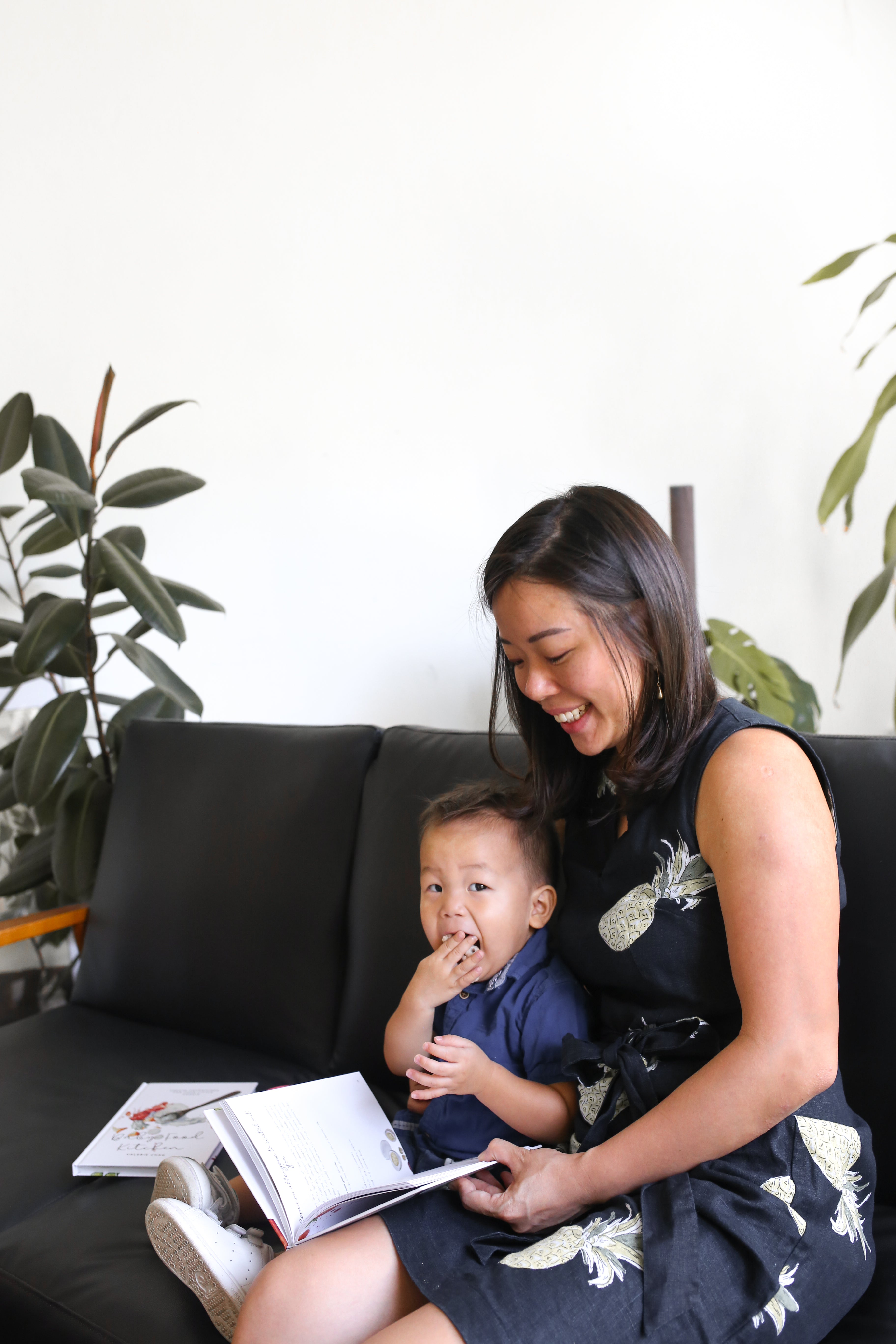 Baby enjoying baby puffs with Mom reading 