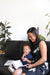 Baby enjoying baby puffs with Mom reading 